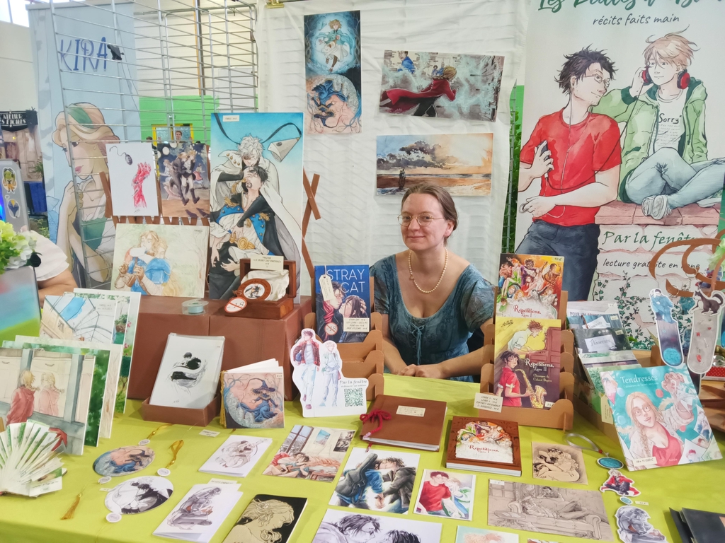 Photo d'Astate tenant son stand en festival.