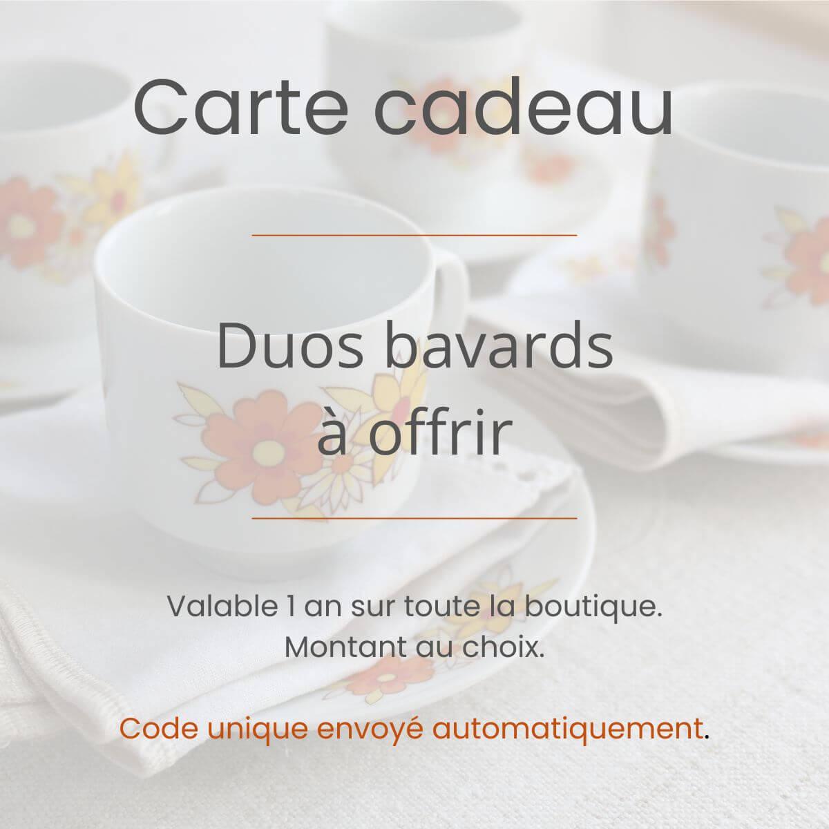 Tasses en porcelaine ancienne décorées de fleurs orange et jaunes, posées sur une serviette en lin ancien.