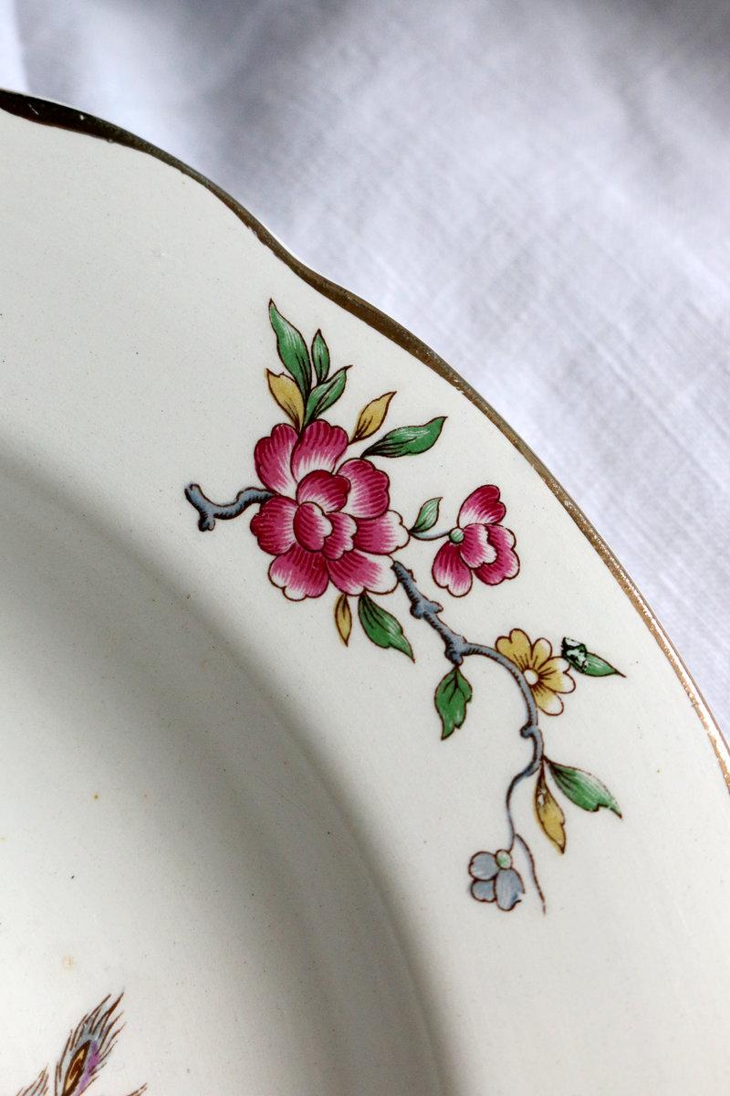 Assiette ancienne décorée de motifs floraux, destinée à être transformée en petite création pour la table.