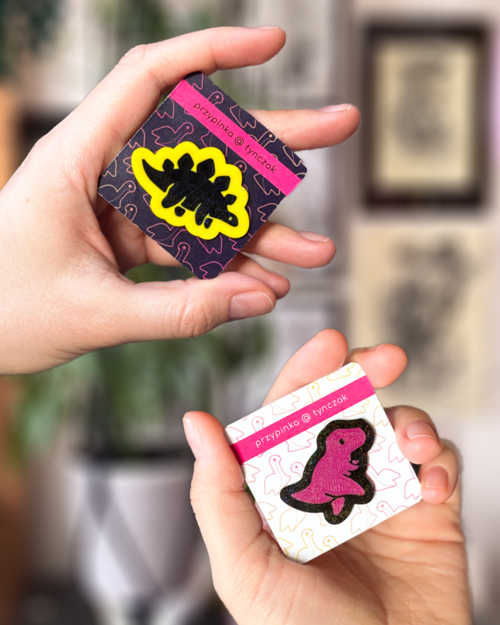 odnośnik do podstrony sklepu z przypinkami, na zdjęciu przypinka w kształcie tyranozaura