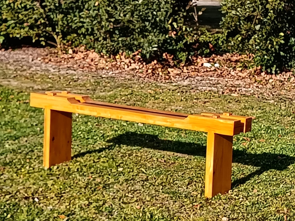 Banc de style japonais en pin verni, revisité par l'atelier d'ébénisterie.