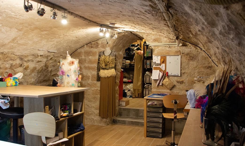 coulisses de l'atelier, avec la zone de travail, les mannequins et les plumes