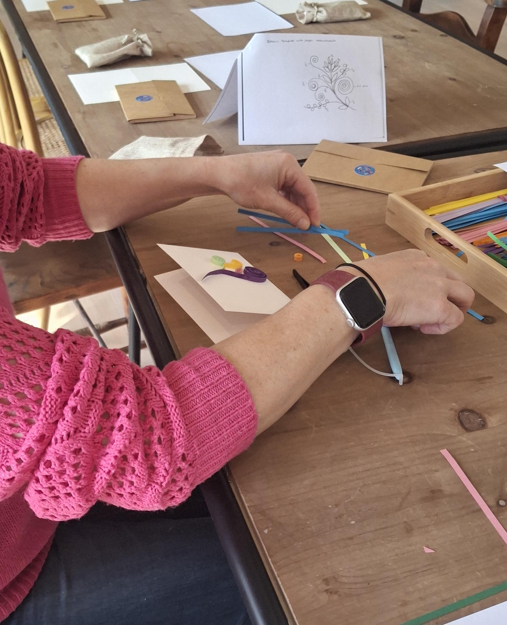 Picture of a heart that is filled with red and pink swirls of paper using the beautiful ancient art technique of quilling. The reader is being invited to discover more about the mindful flow of quilling workshops.