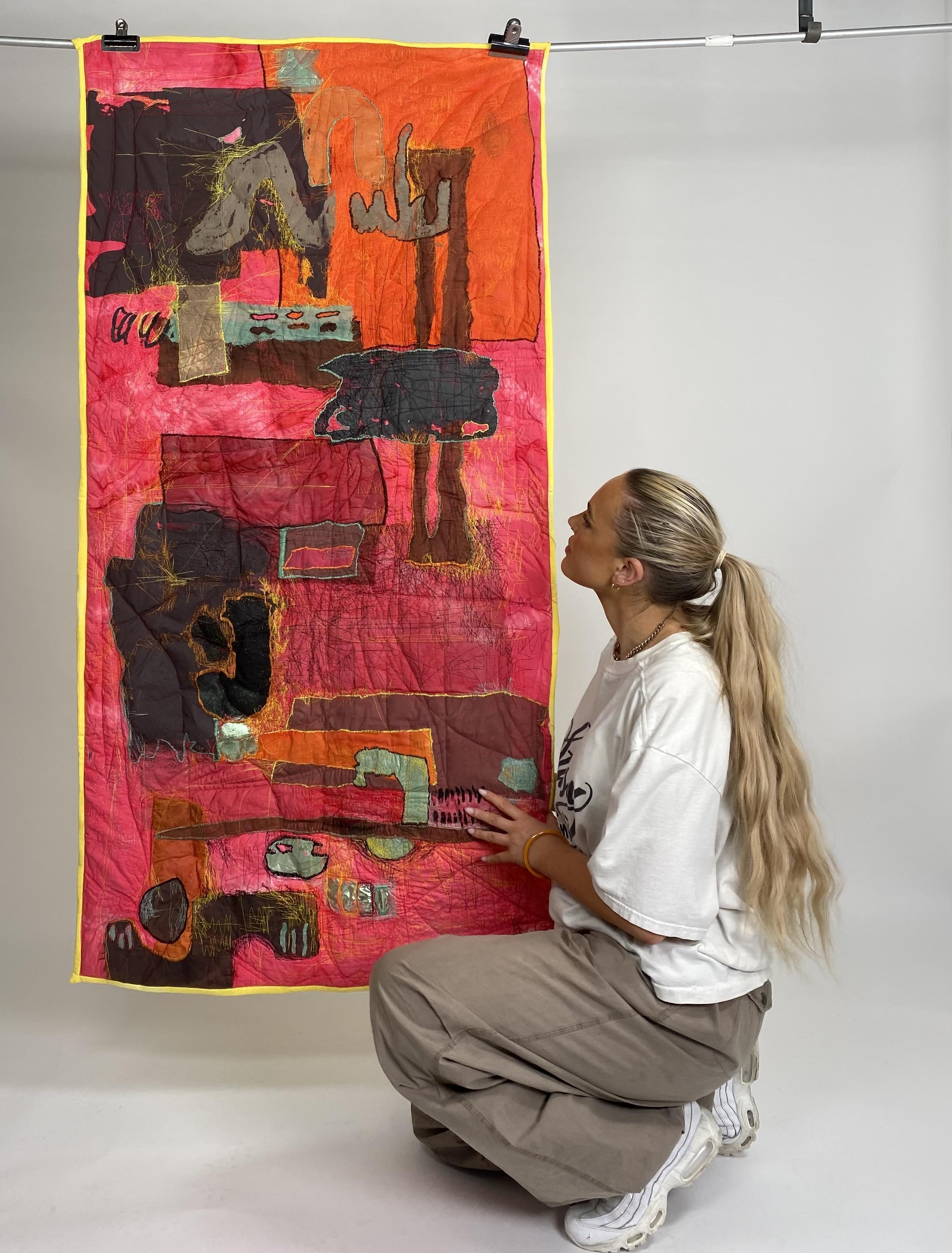 Amber Lily Studio posed next to her artwork 'Everyday'.