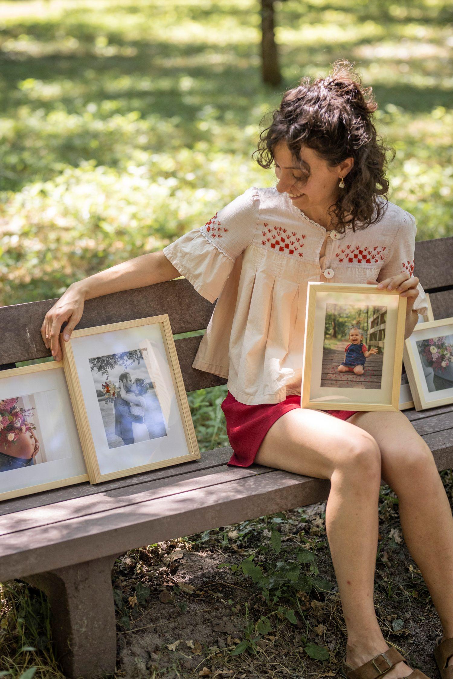 Portrait de Nei, fondatrice d’Hestia Broderies dans son atelier. Fils à broder, photos et carnets de croquis avec des plantes vertes.