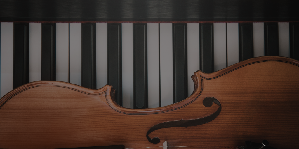 Un piano en fond et un violon de face au premier plan.