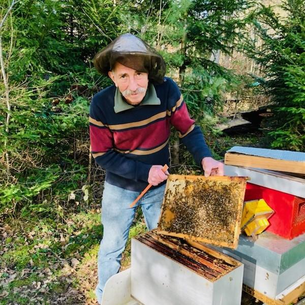 Christian Morel, apiculteur dans les Vosges en train de récolter son miel