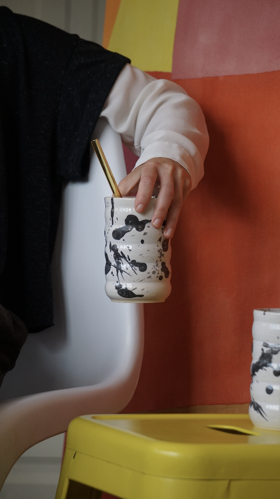 Handmade ceramic cups in 3 different sizes with a bubble shape. The cups have a matte white glaze that lets the speckles of the clay shine through and they are displayed on a white background. There are seashells next to the cups, and lavendar in the largest of them.