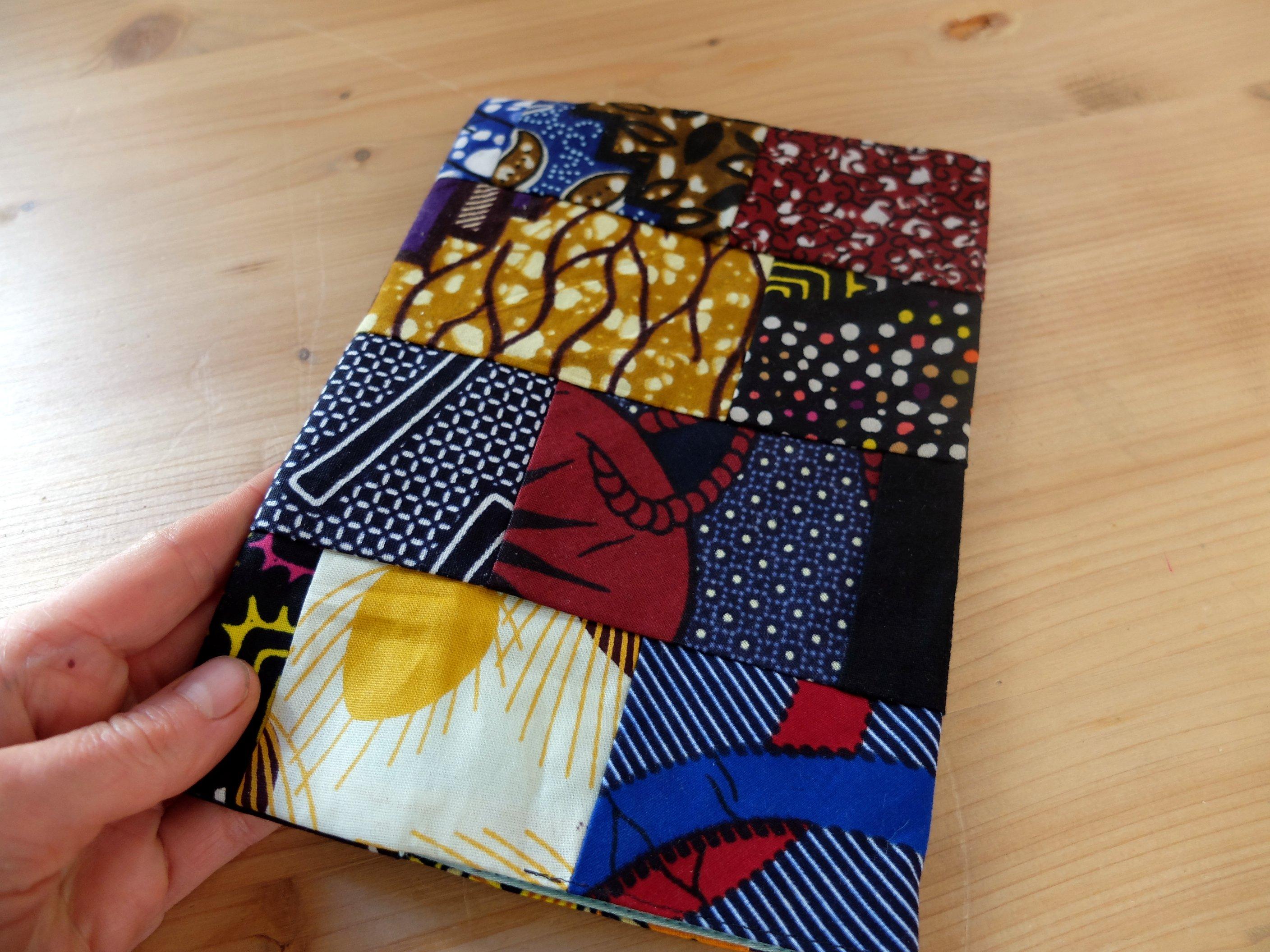 Pochette à carnet de voyage, pochette à agenda, en patchwork de wax. Pièce unique. Confection artisanale éthique et écoresponsable.