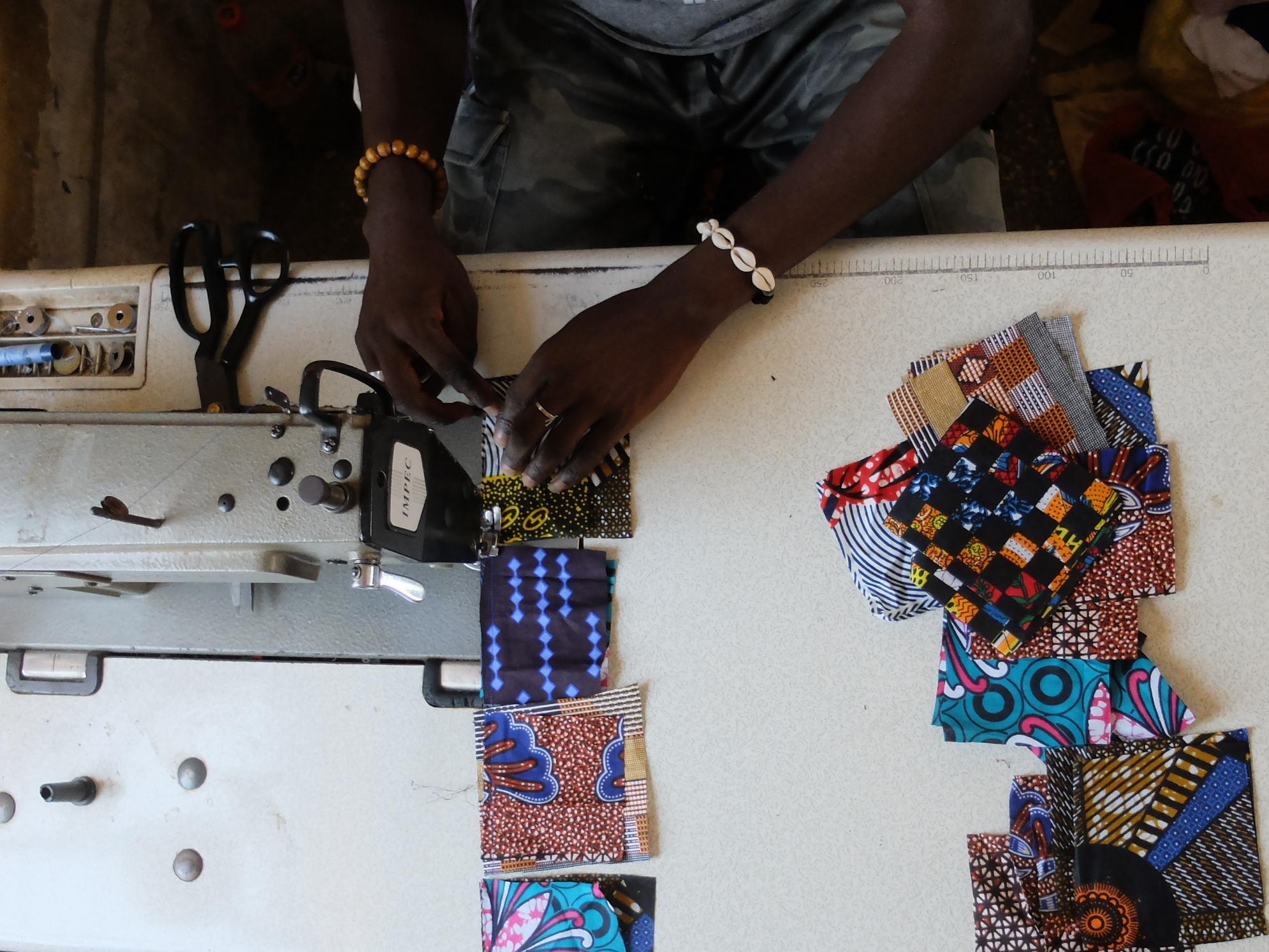 Fabrication au Sénégal du patchwork njaxass par Diegane, jeune apprenti tailleur, dans son atelier à Ndangane