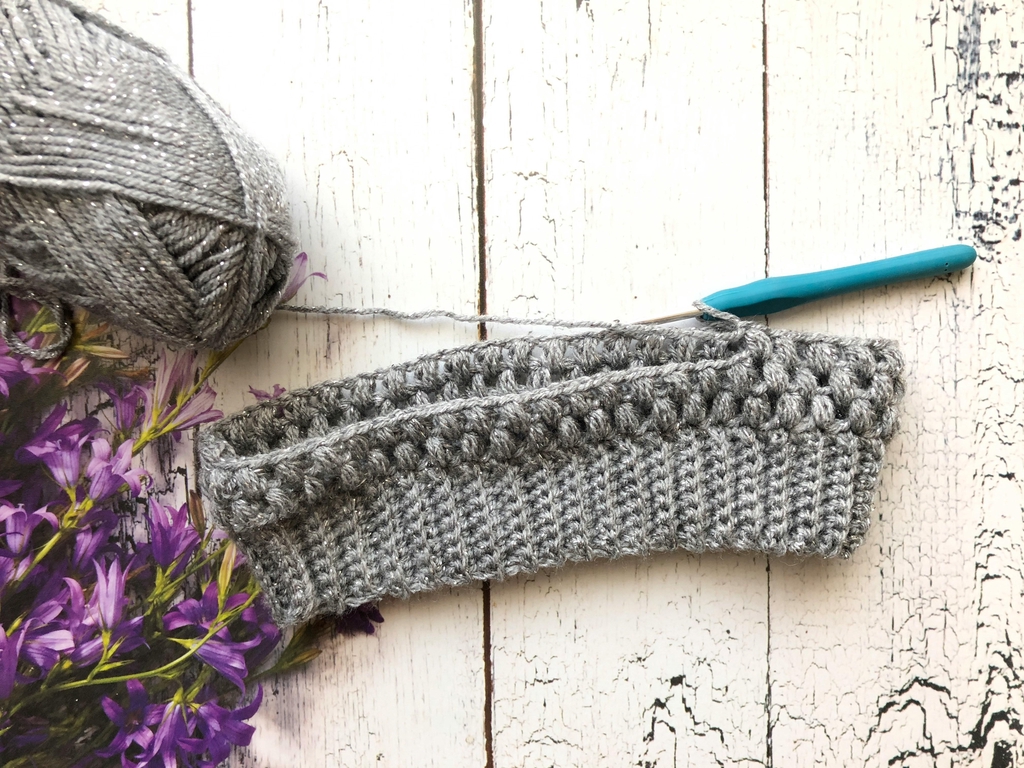 Handgehäkeltes Modeaccessoire aus Naturfasern mit gleichmäßigem Maschenbild, sorgfältig ausgewählten Garnen und hochwertiger Verarbeitung.
