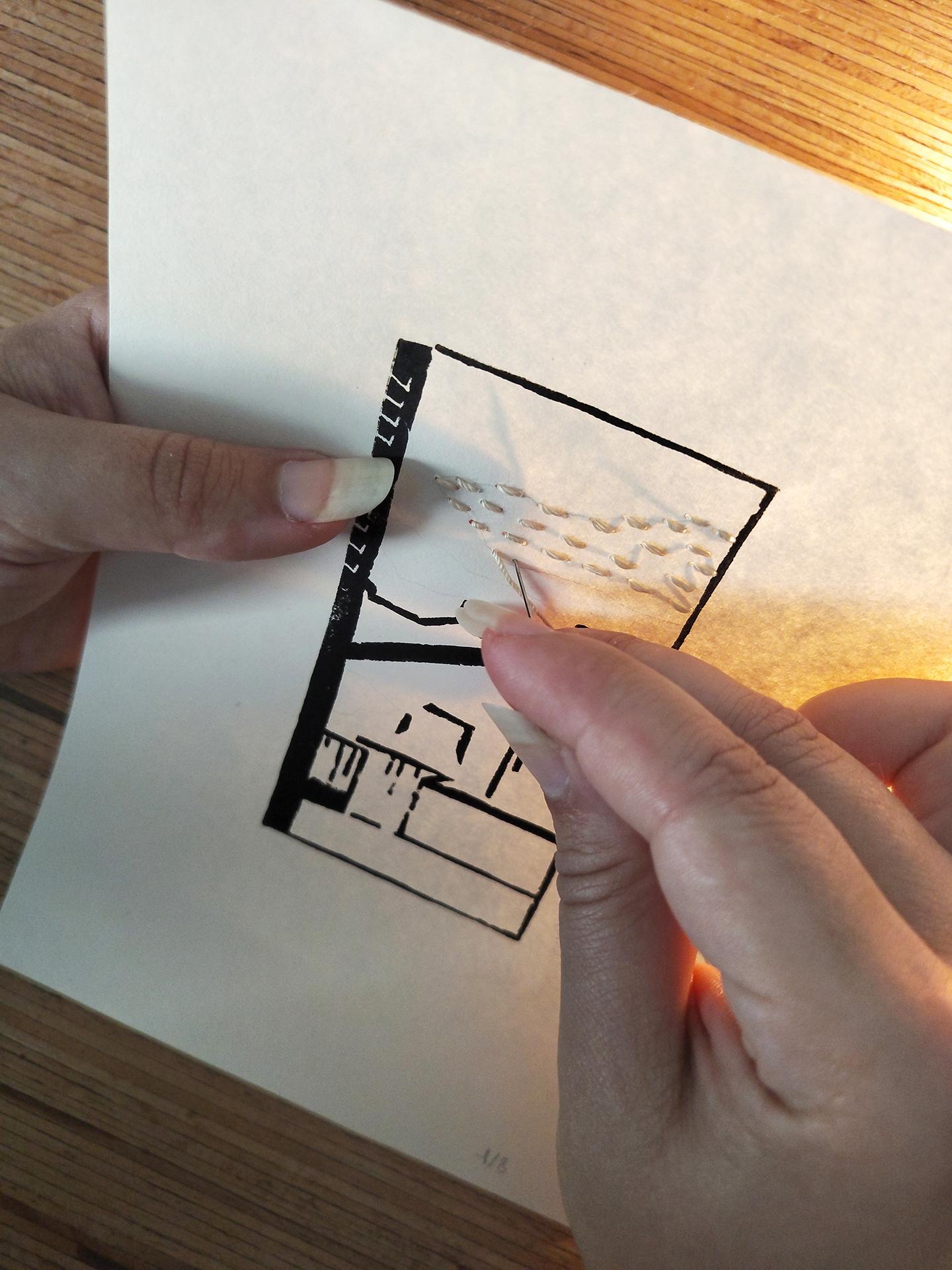 Linogravure en train d'être brodée à la main.