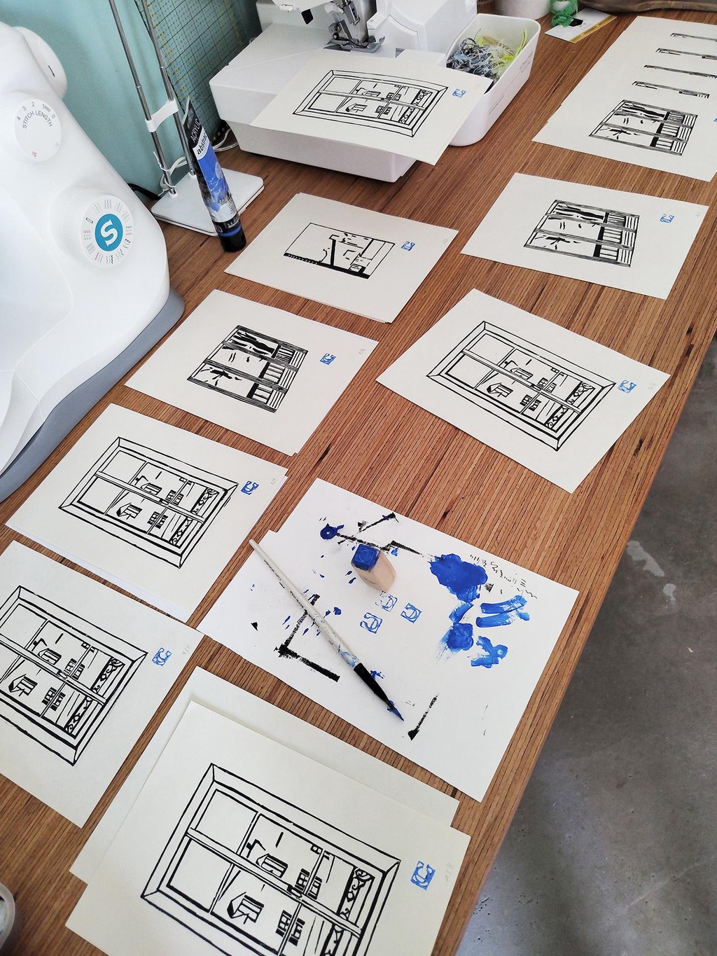 Image de l'atelier avec plusieurs gravures sur le plan de travail et le tampon signature Nuit de Cobalt.
