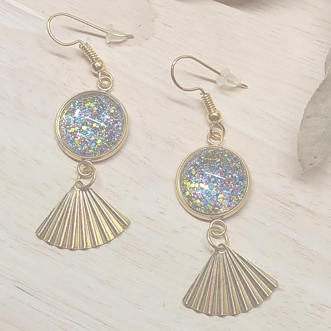 Boucles d'oreilles avec des cabochons incrustés de paillettes et breloques