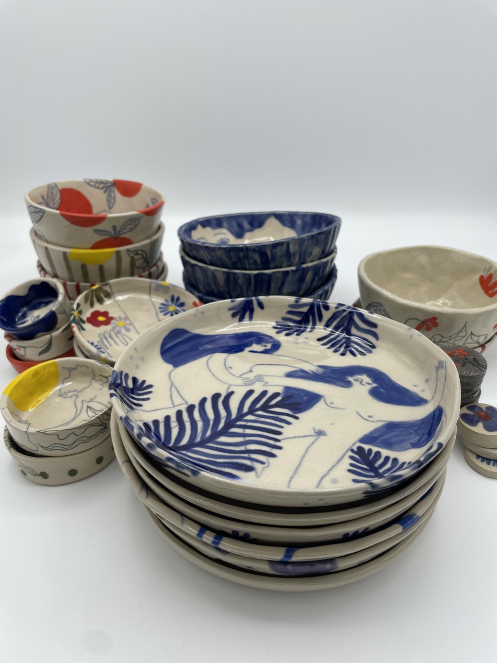 Céramiques illustrées. Des objets en grès décorés d’illustrations inspirées du monde animal, végétal et de présences féminines, où chaque pièce devient une petite scène unique.