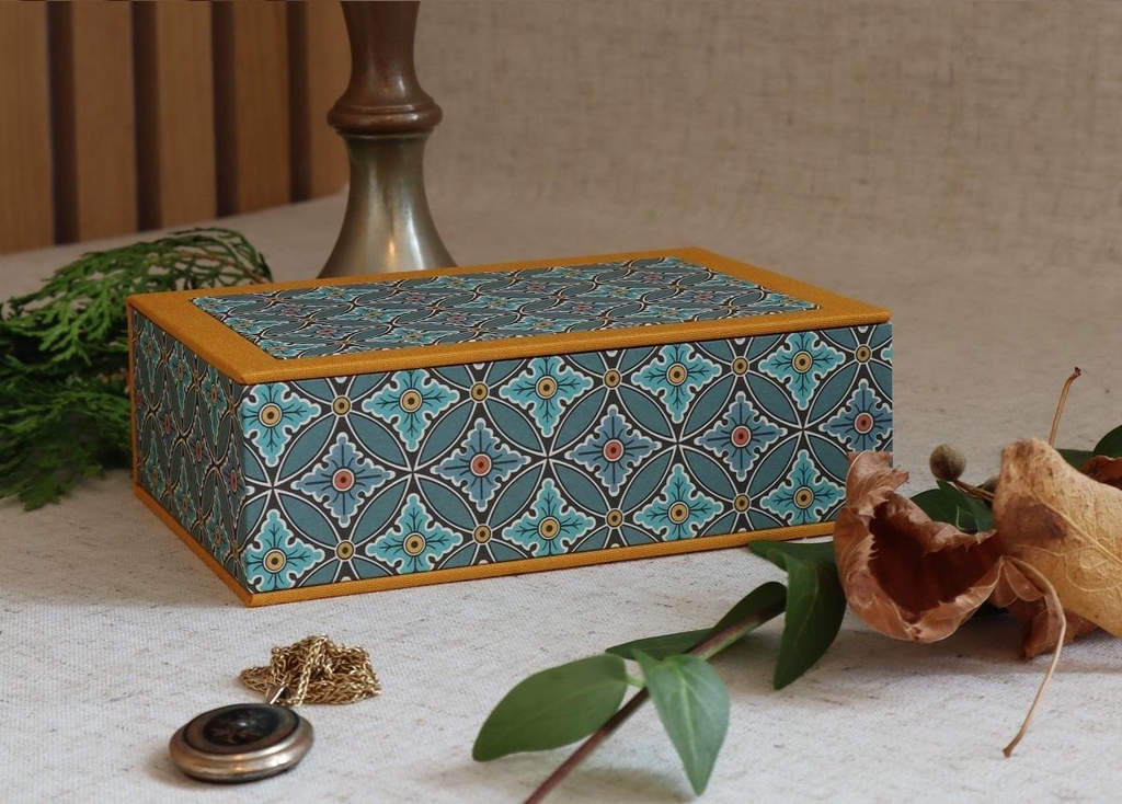 A handmade rectangular jewellery box with inlaid paper on the lid.