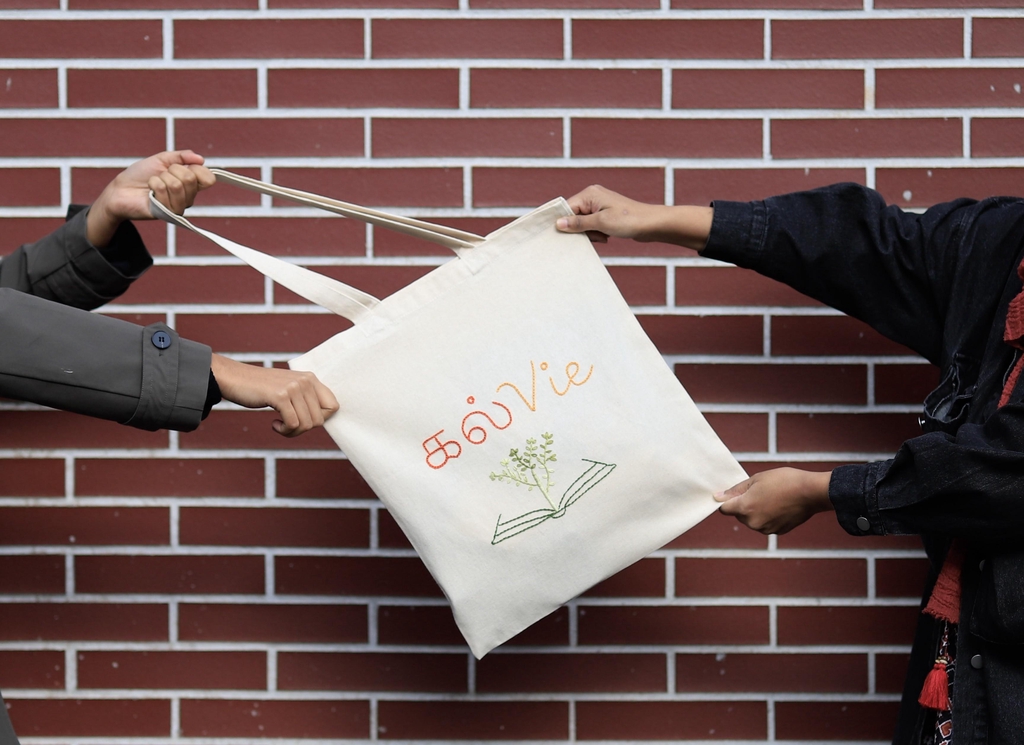 Femme portant le tote bag Initiatea, modèle lotus brodès à la main d'inspirations indienne