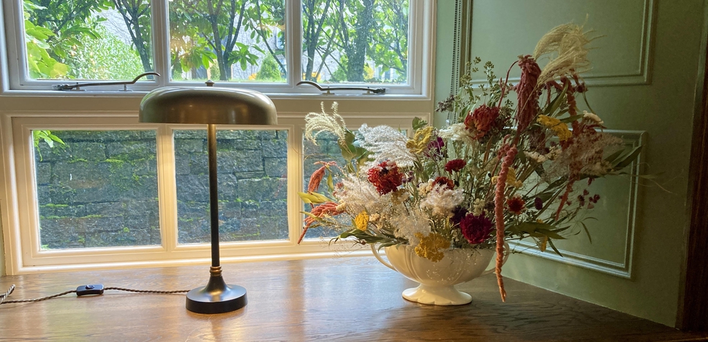 mantle vase with beautiful, elegant, sustainable dried flower arrangement on window sill in elegant hotel