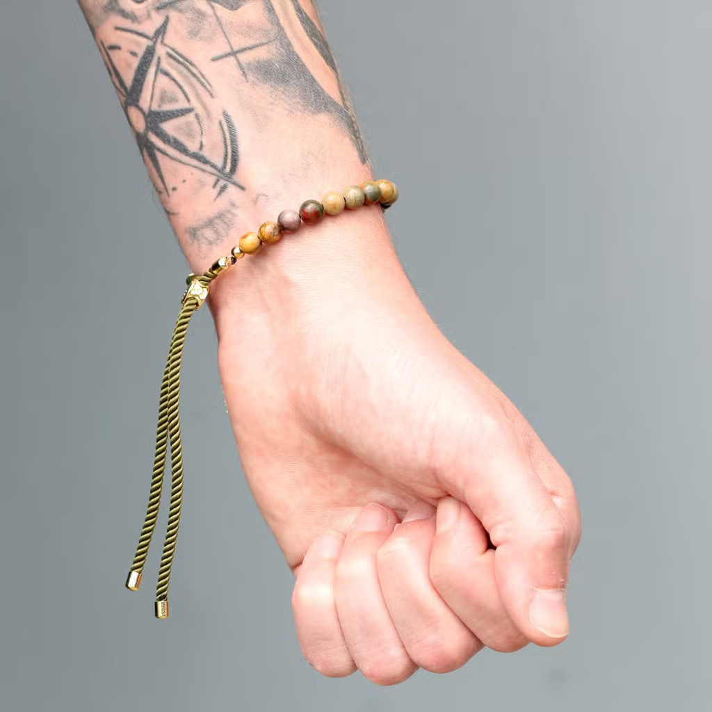 Tiger eye bracelet on black string worn on wrist, 18K gold plated