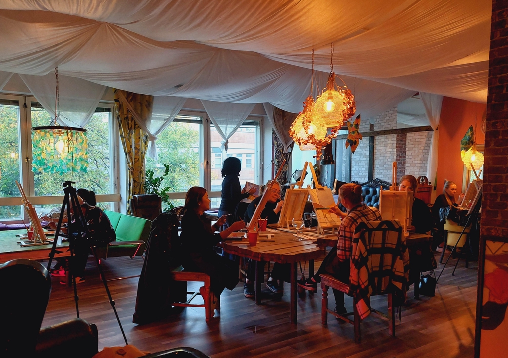 Art & Mingle workshop photo. A picture of people painting with guidance of the artist. The workshop is held in a nice private space upstairs  of Bar Bizarre. 