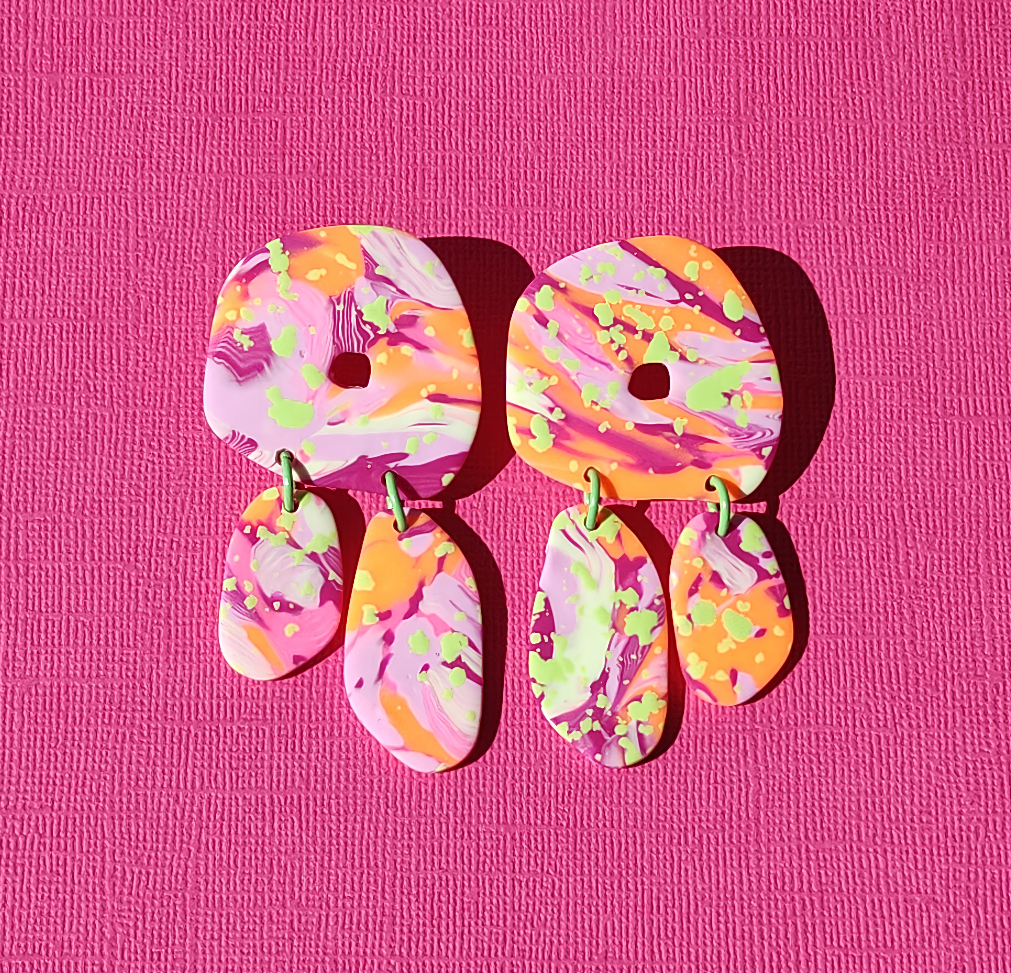 Handgemaakte statement oorbellen uit de Marea collectie van Miel-oorbellen, met gemarmerde patronen in roze, oranje, fuchsia en frisgroen.