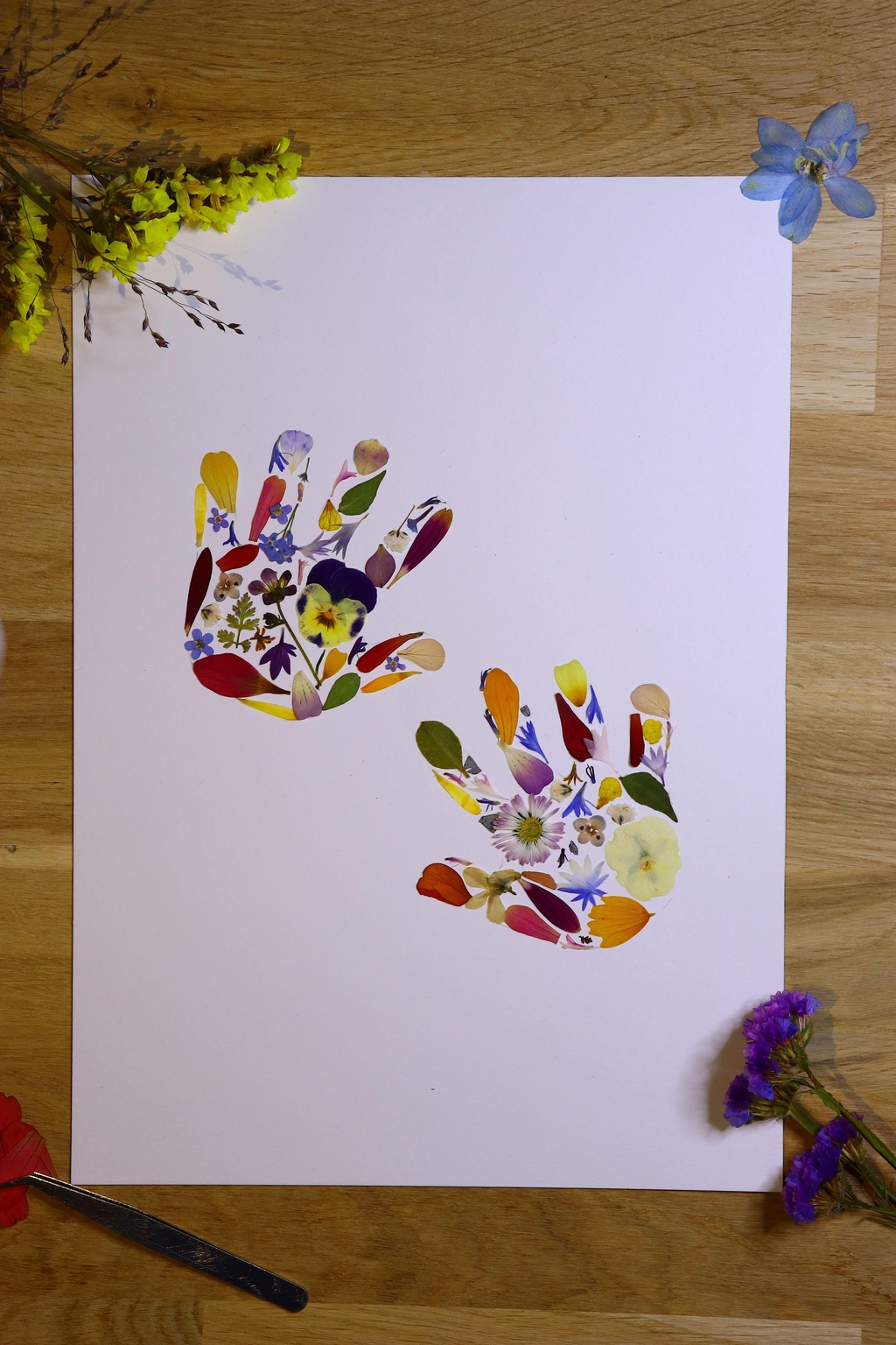 Herbier personnalisé pour cadeau de naissance, montrant un tableau de fleurs pressées avec des petites mains de bébé.