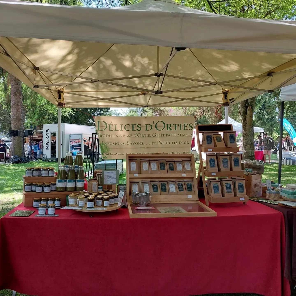 Stand Délice d'Orties sur un marché normand, avec sa gamme complète de produits à base d'ortie : infusions, pesto, gelées et savons
