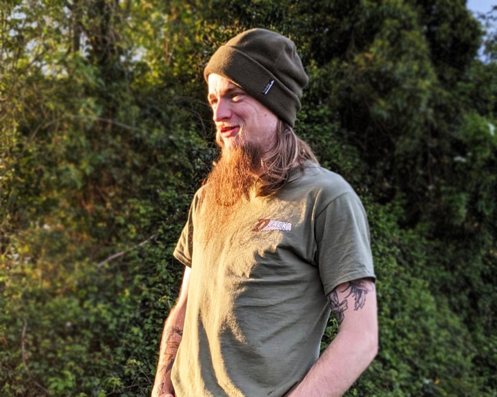 Jack the carpenter standing in front of a hedge