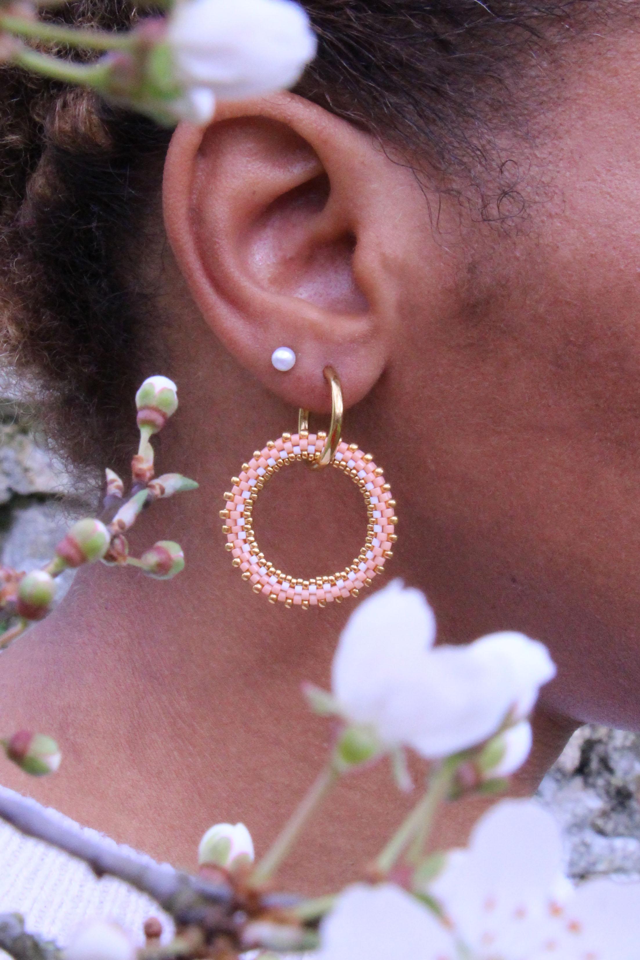 La collection de boucles d'oreilles "Premières fleurs" est faite main en France. Les bijoux sont déclinés dans des coloris Rose pêche.