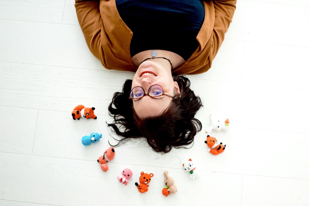 photo présentant Elodie la créatrice OmeBonheurs entourée de plusieurs de ces créations minigurumis 