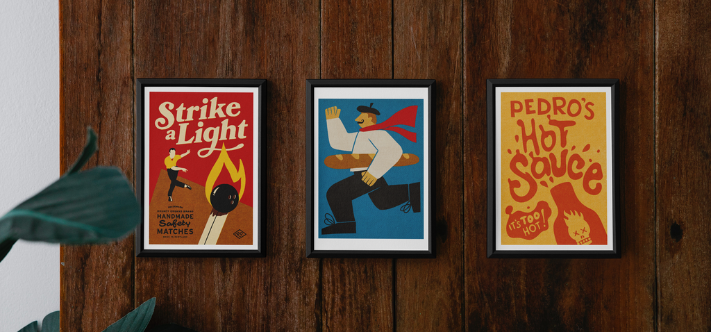 Three of Rodney Organs' art prints framed on a wooden wall