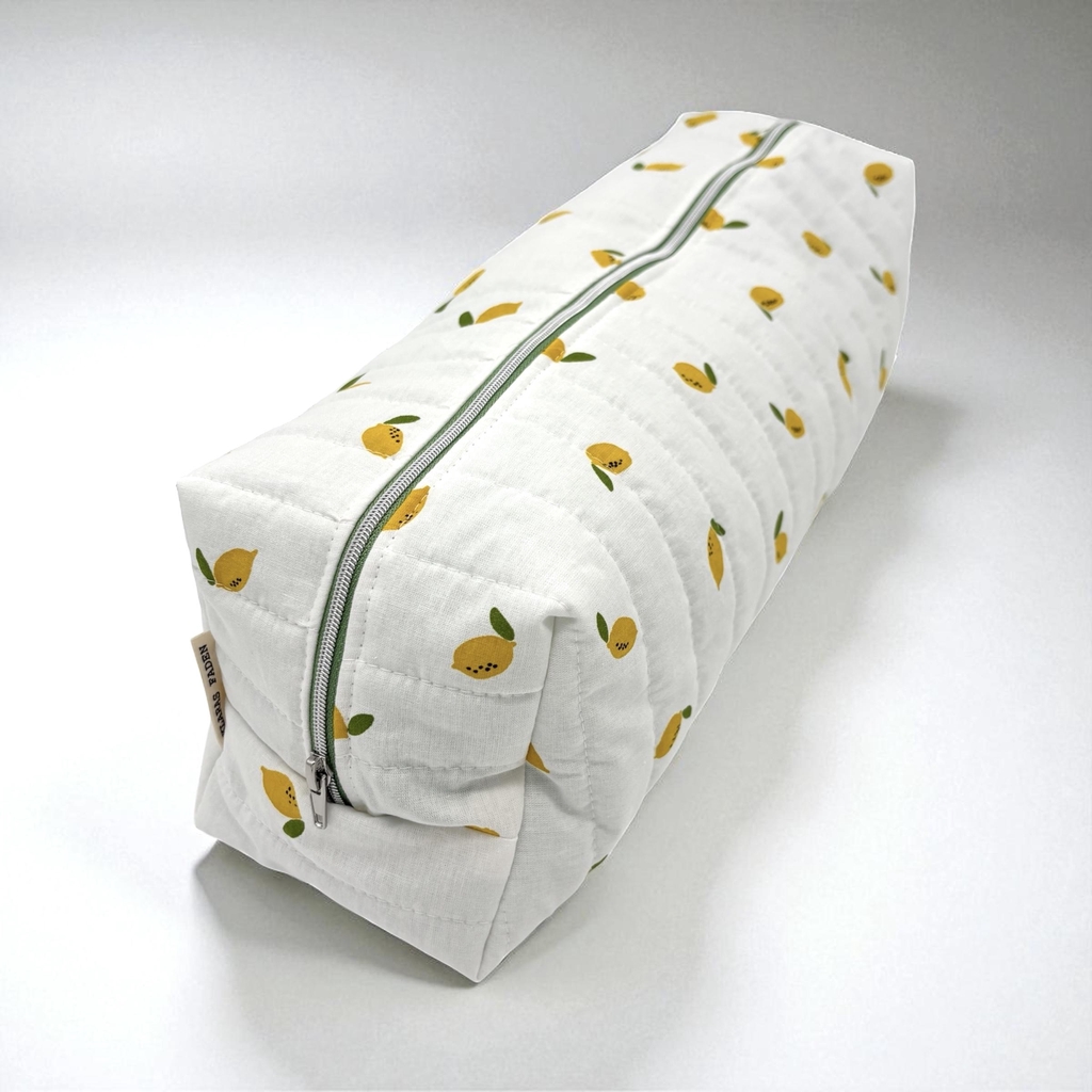 Tasche für Haarstylinggeräte und -produkte aus weißen Steppstoff mit Zitronen drauf