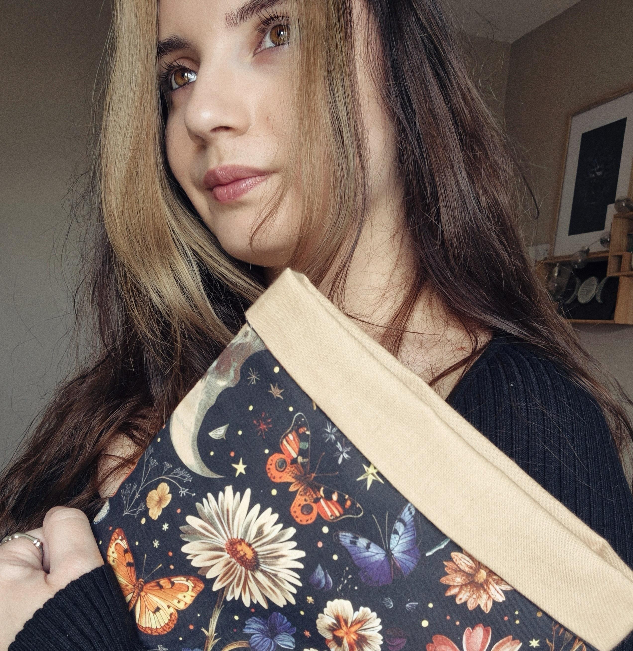 Portrait de Maëva, la créatrice de Amayë avec une de ses pochettes artisanales faits main en Provence en tissu fleuri.
