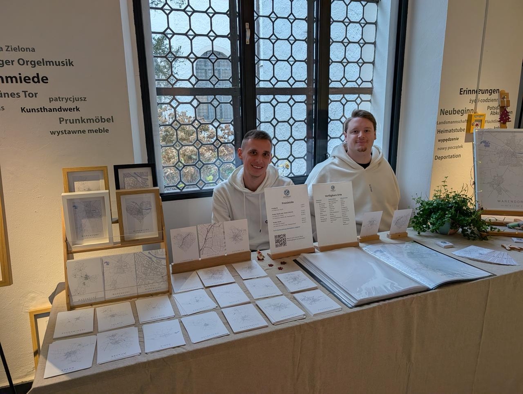 Verkaufsstand mit minimalistischen Stadtplan-Postern und Postkarten von Bielefeld, inklusive gerahmter Kunstdrucke und Preisliste.