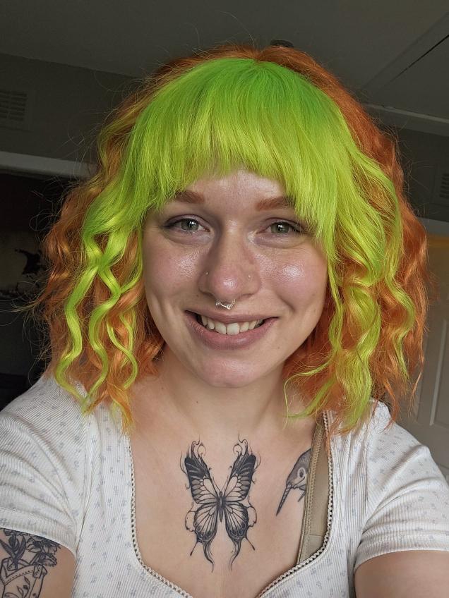 Custom wig review picture showing customer wearing copper and lime green curly human hair wig