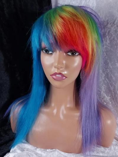 Wig review photo showing a half pastel purple half bright blue scene wig with a rainbow fringe