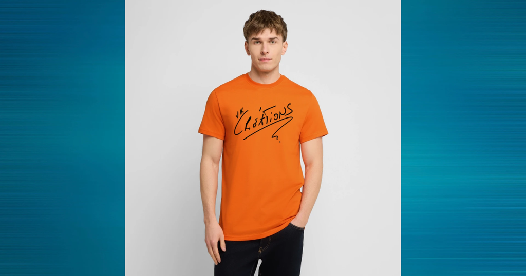 T-shirt orange porté par un modèle, imprimé du logo manuscrit VK Créations en noir.