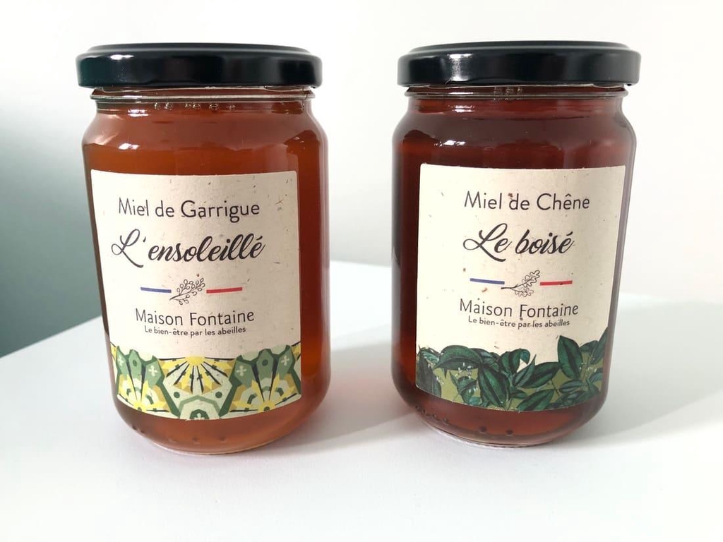 2 pots de miel sur un fond blanc