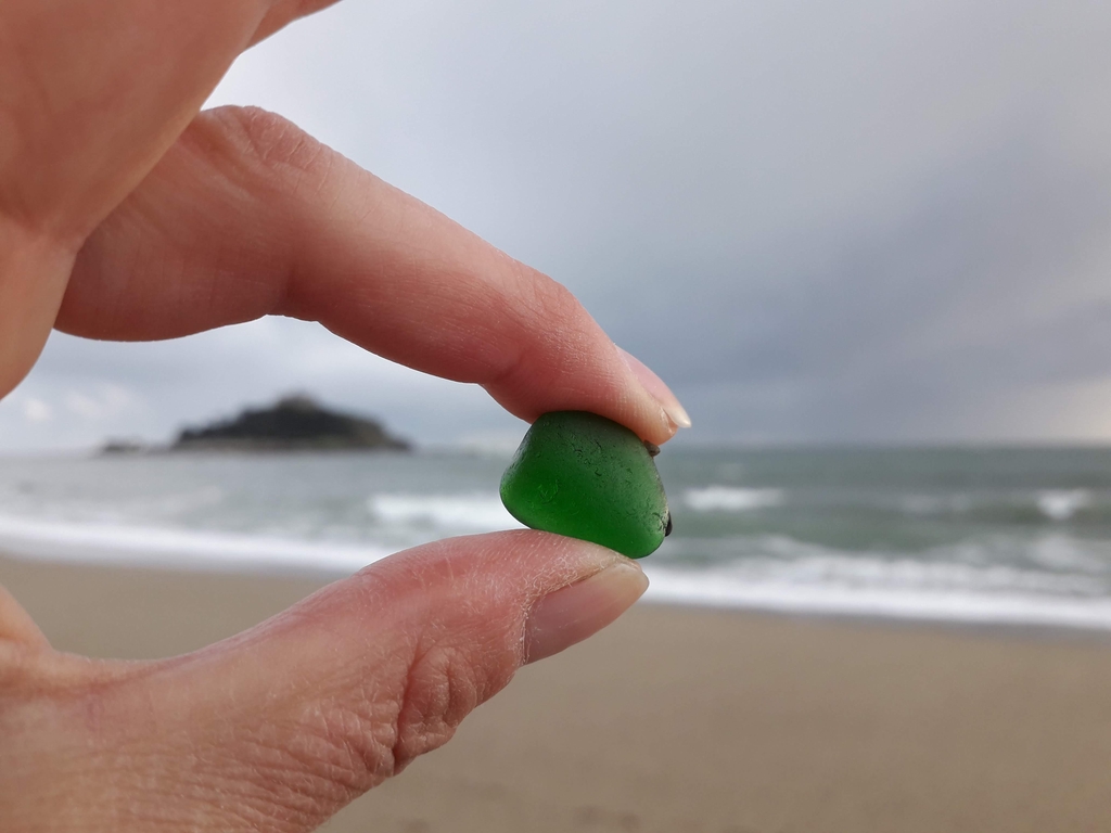 Sea glass found on Marazion beach, Cornwall with St. Michael's Mount in the background. Handmade sea glass jewellery by CornishFinds.