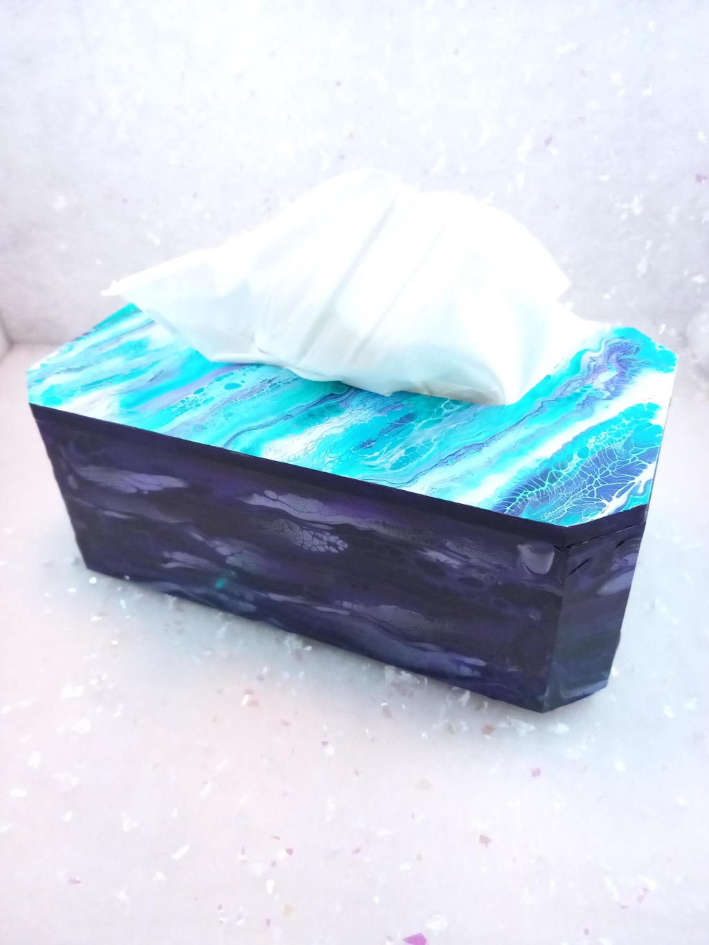 Boite de mouchoirs, longue, ouverture sur le dessus. Dessus turquoise, mauve, base violet profond.