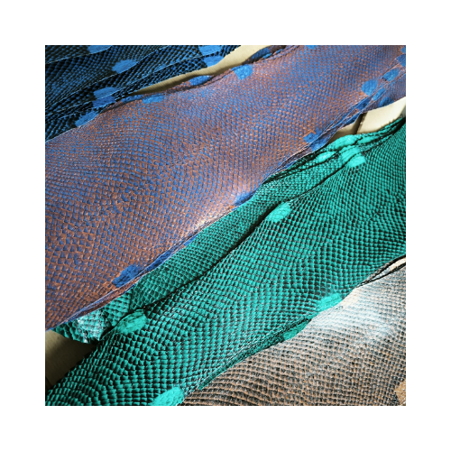 Photo carré avec des peaux de saumon, posées sur une table. On peut voir l'angle gauche de la photo avec des peaux de couleur bleu, puis bleu odyssée, puis vert et marron.