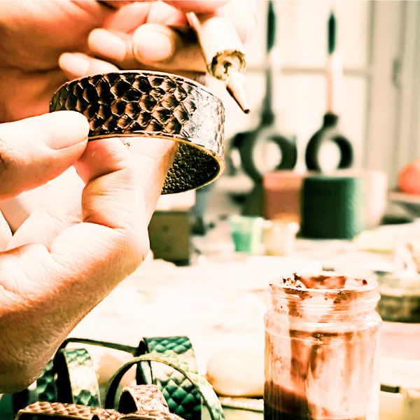 Photo savoir-faire artisanat maroquinier bijoux haute fantaisie cuir marin saumon galuchat atelier geste précision minutie qualité durable 