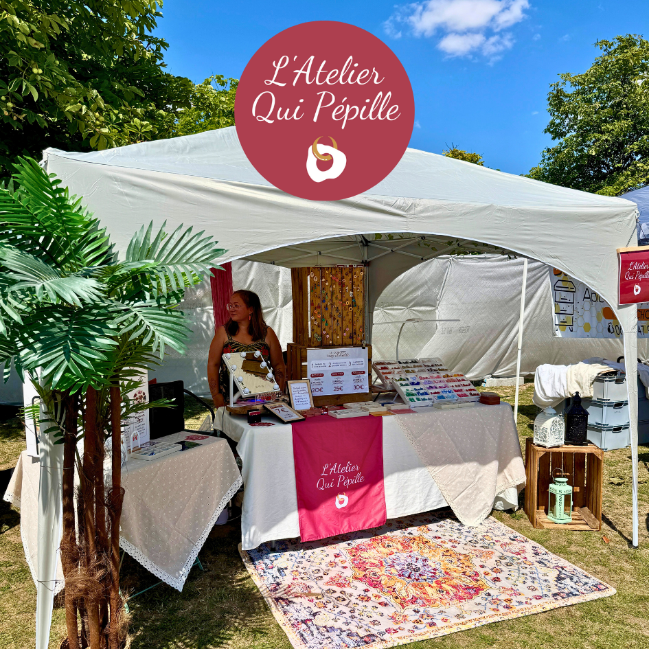 Stand de L’Atelier Qui Pépille lors d’un festival, barnum décoré présentant des boucles d’oreilles interchangeables en argile polymère, créations artisanales uniques et faites main en France.