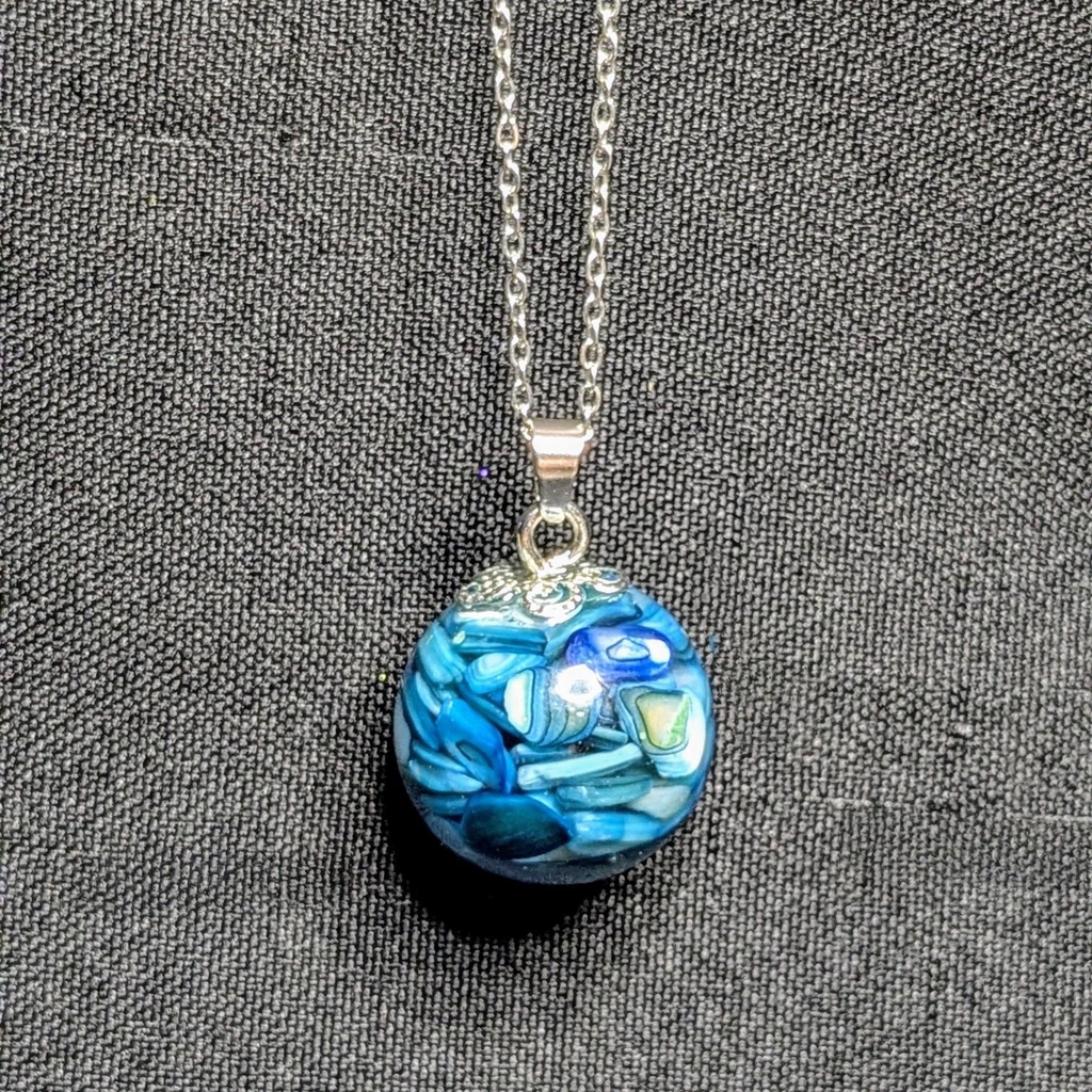 Une photo d'un pendentif bleu aux détails faisant penser à de l'opale.