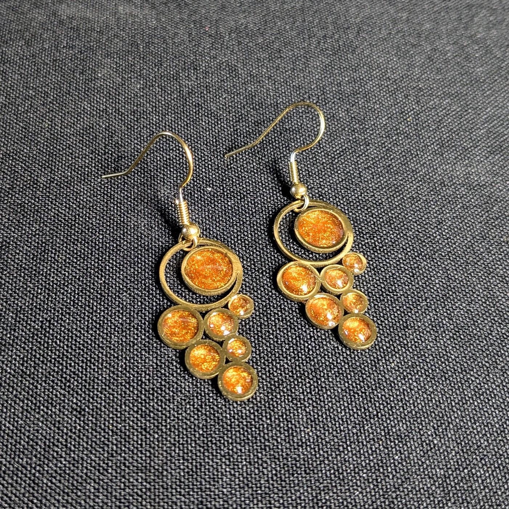 Une photo d'une paire de boucle d'oreille ressemblant à des grappes de raisins en ambre.