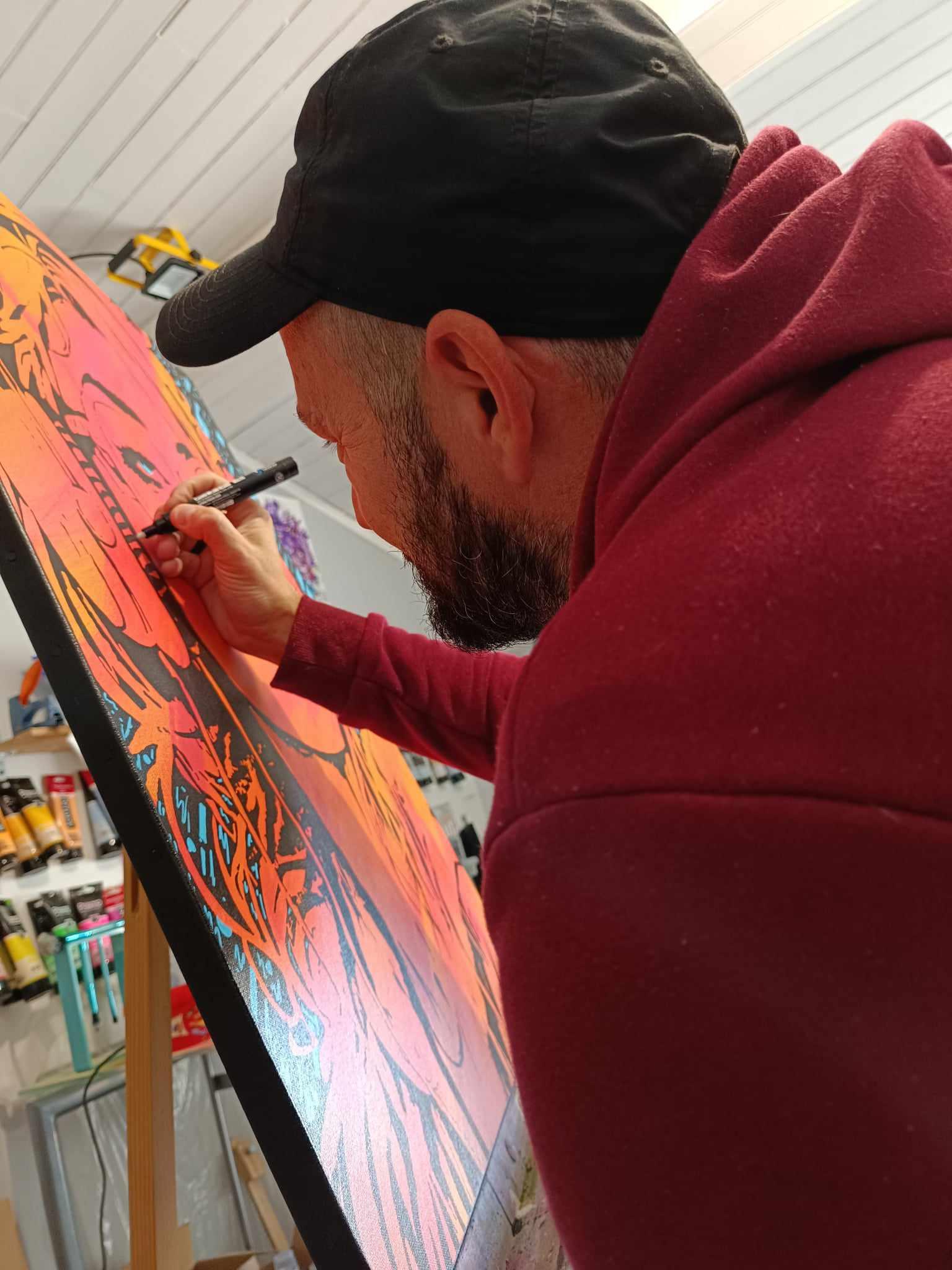 Tony Debs dans son atelier, entouré de ses œuvres, sculptures et matériel artistique