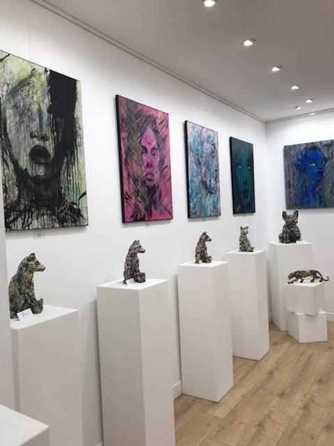Tony Debs lors d’une exposition devant plusieurs de ses peintures contemporaines
