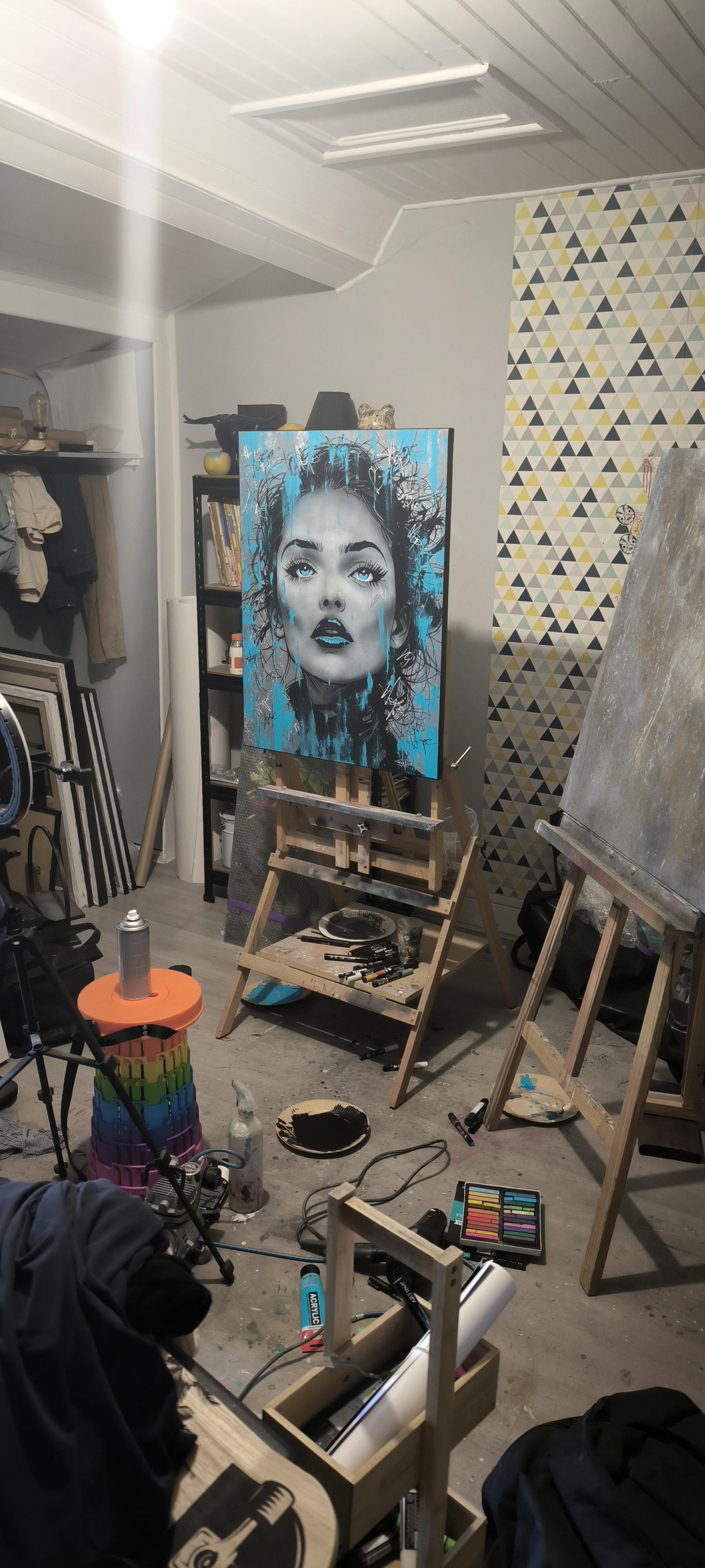 Atelier d’artiste avec chevalet, matériel de peinture et portrait contemporain en cours de création