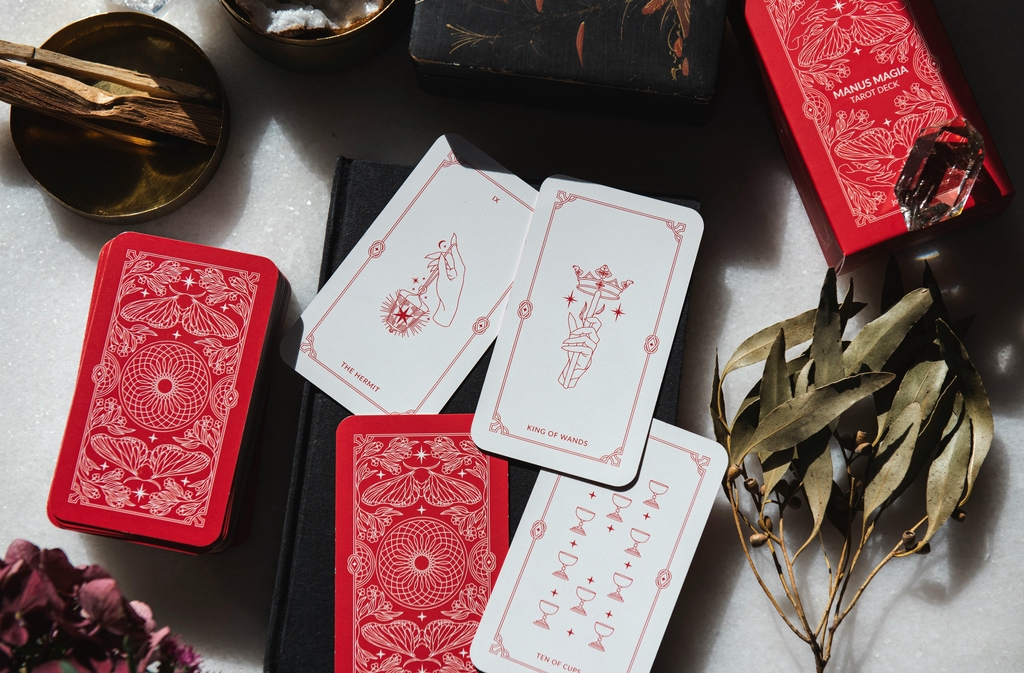 A banner picture showing white and red Tarot cards with simple illustrations lying flat on the table.