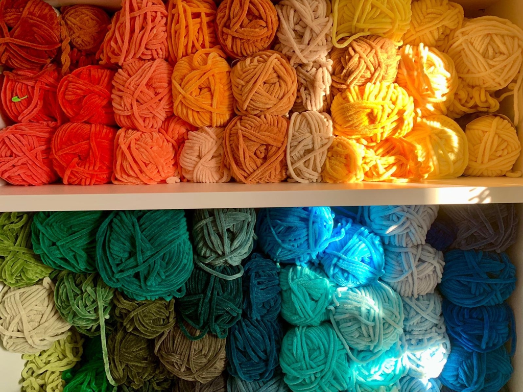 Yarn shelf with different colours of yarn balls. 